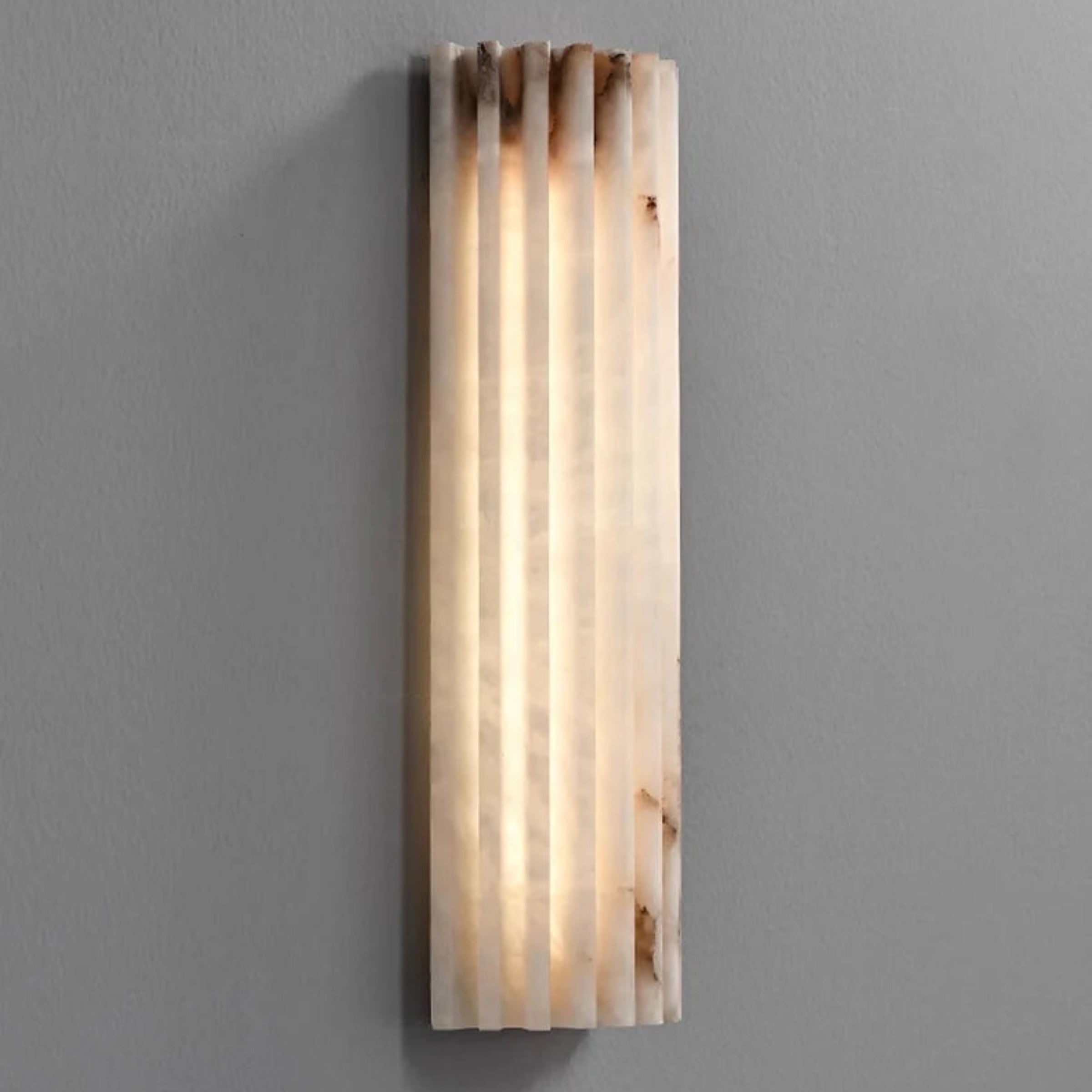 Wall-mounted light fixture with a ribbed design on a gray wall