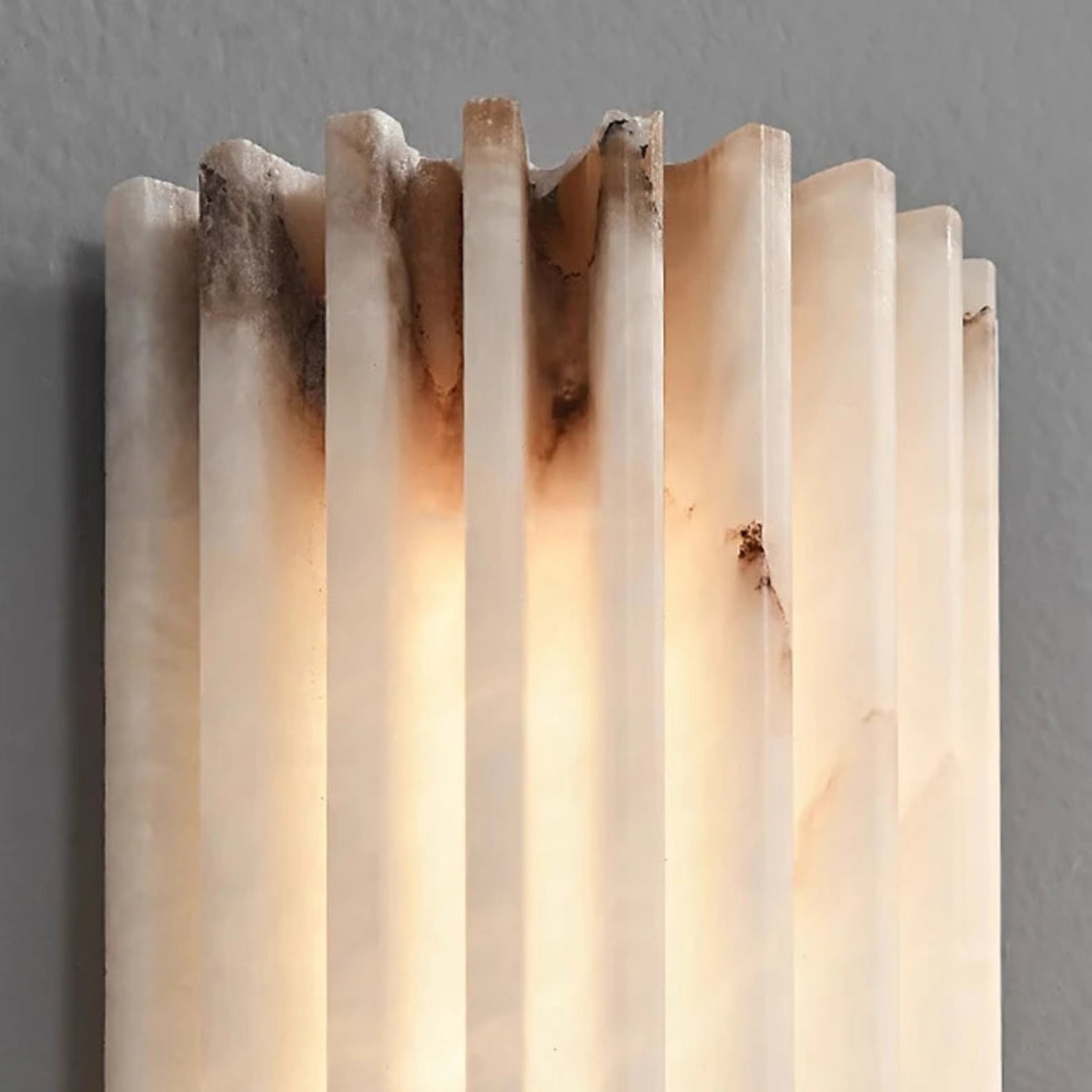 Decorative wall sconce with a warm glow on a gray background