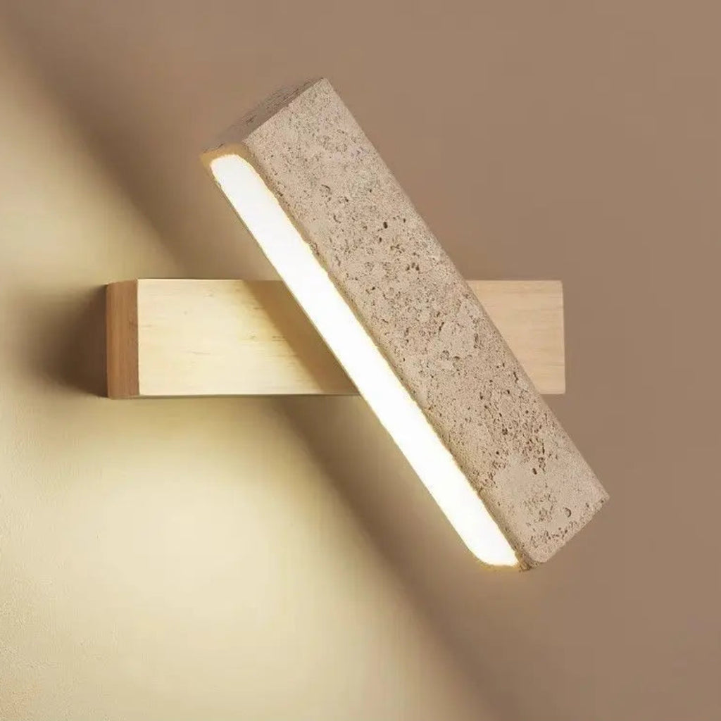 Modern wall light fixture with concrete and wood design on a beige wall.