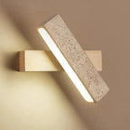 Modern wall light fixture with concrete and wood design on a beige wall.