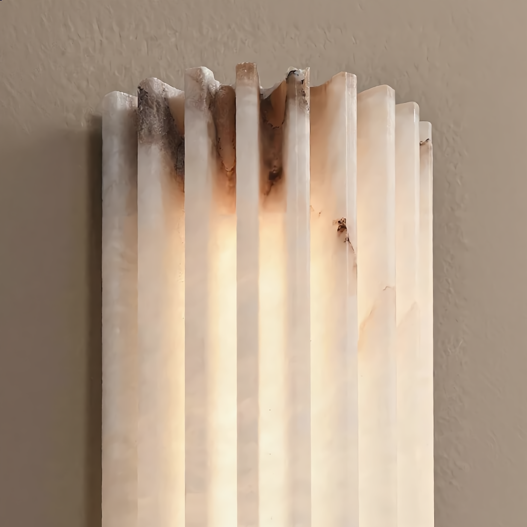Wall-mounted light fixture with a striped design on a neutral background