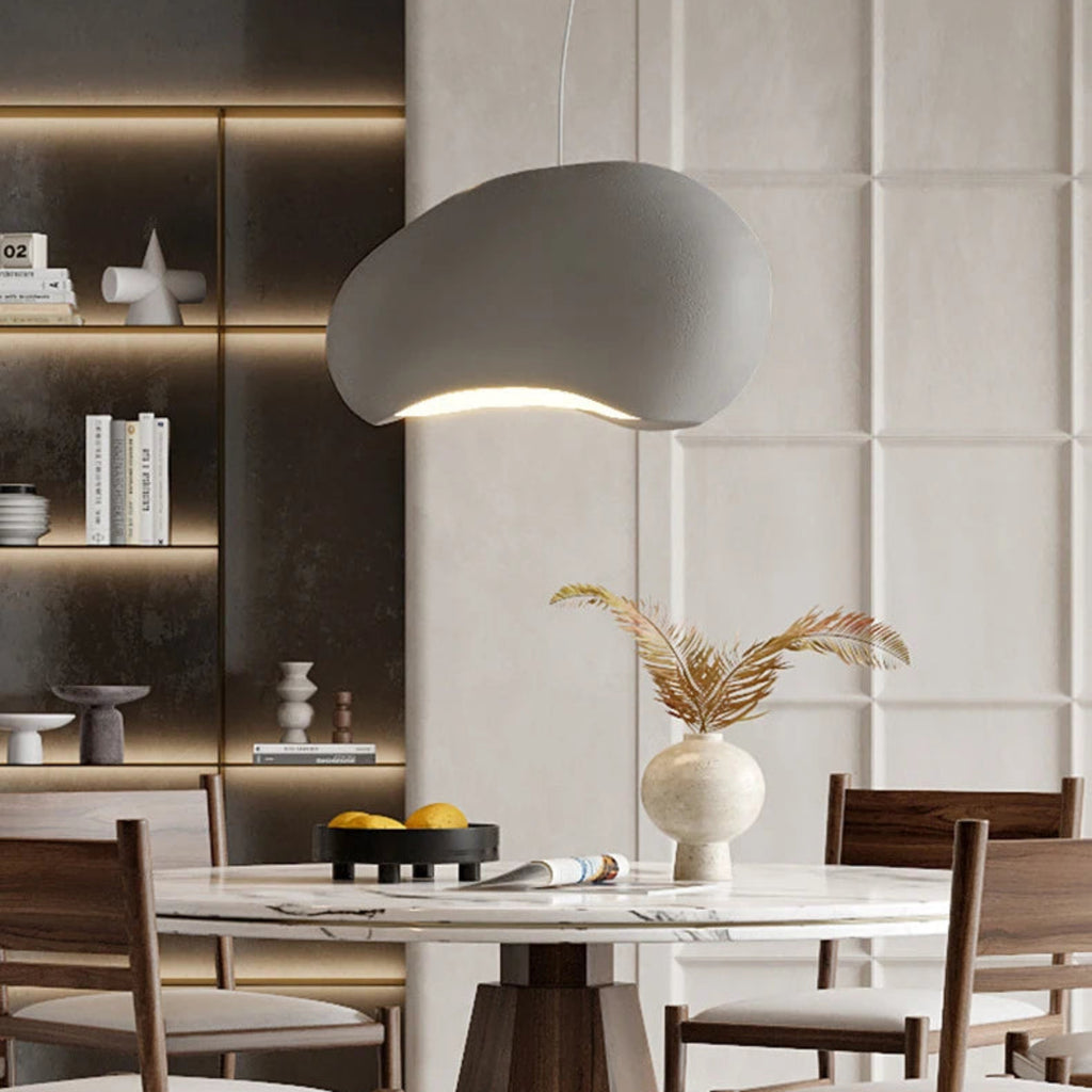 Modern dining room with a gray pendant light, marble table, and wooden chairs.