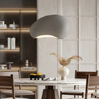 Modern dining room with a gray pendant light, marble table, and wooden chairs.