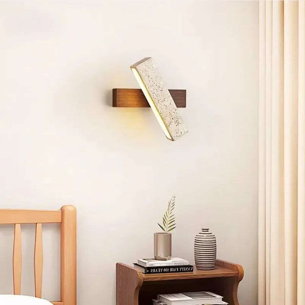 Wall-mounted light fixture in a bedroom setting with a wooden headboard and nightstand.