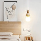 Modern bedroom with wooden headboard, abstract wall art, and pendant light.