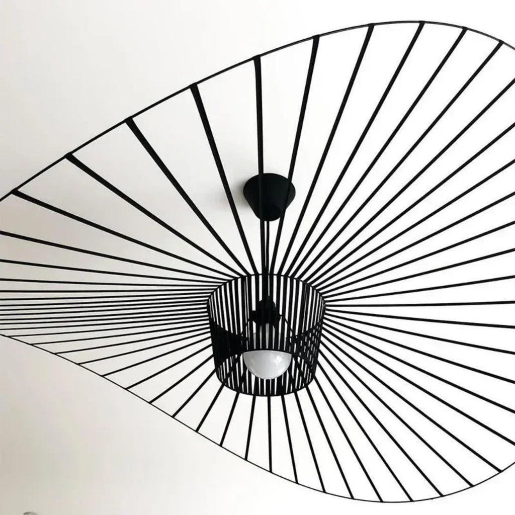Ceiling light fixture with black metal sunburst design on a white ceiling