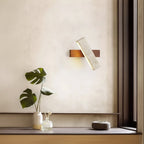 Modern wall light fixture on a neutral wall with decorative elements.