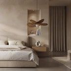 A modern minimalist bedroom featuring a low-profile platform bed with neutral beige bedding, flanked by floating wooden nightstands. The room has a warm, textured plaster wall, two matching wooden ceiling fans hanging from the ceiling, and floor-to-ceiling curtains.