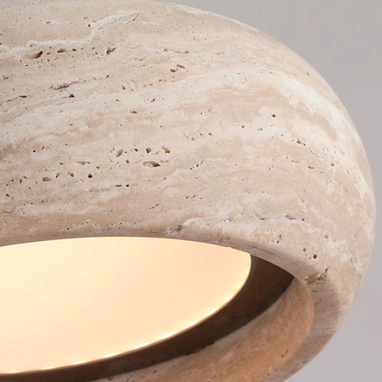 Close-up of a stone-textured lamp with a warm glow on a gray background