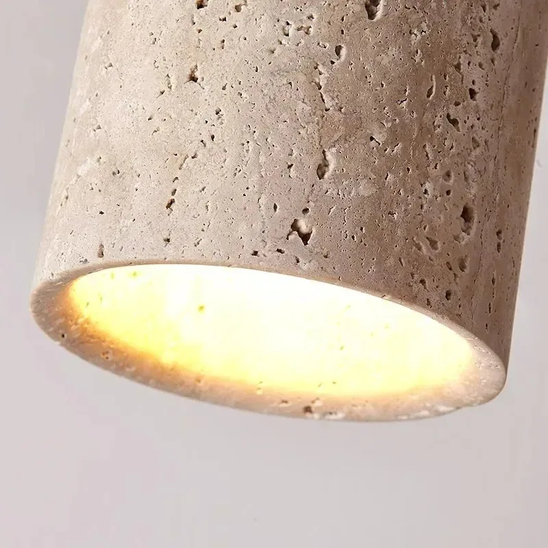 Concrete-textured lampshade with a warm glow on a light gray background