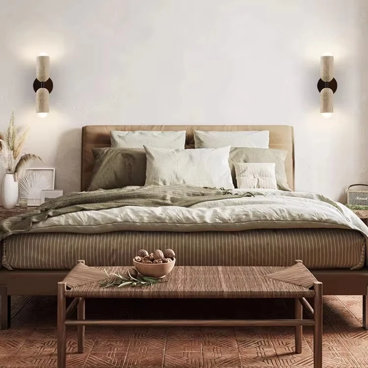 Modern bedroom with a bed, side tables, and wall sconces.