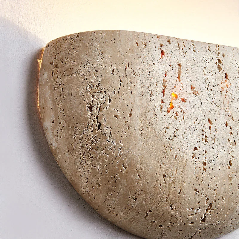 Close-up of a textured stone wall sconce on a white background