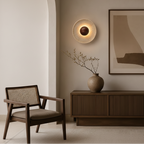 Modern interior design with wall lights, a vase, and abstract art on a neutral wall.
