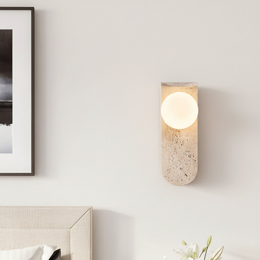 Wall-mounted light fixture on a neutral wall with a vase of flowers in the foreground.