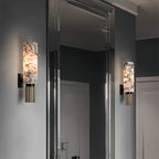 Two wall-mounted lamps with marble-like finish on a gray wall.