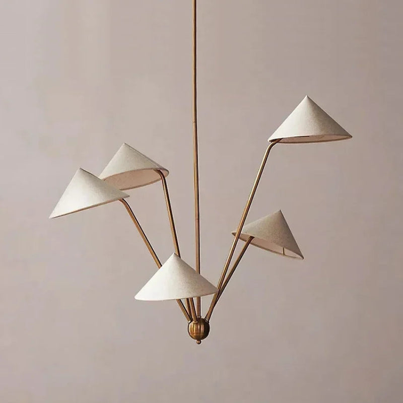 Modern chandelier with white lampshades and gold fixture against a neutral wall.