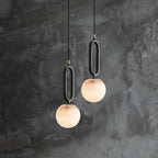 Two modern pendant lights with marble-like finishes hanging against a textured dark wall.