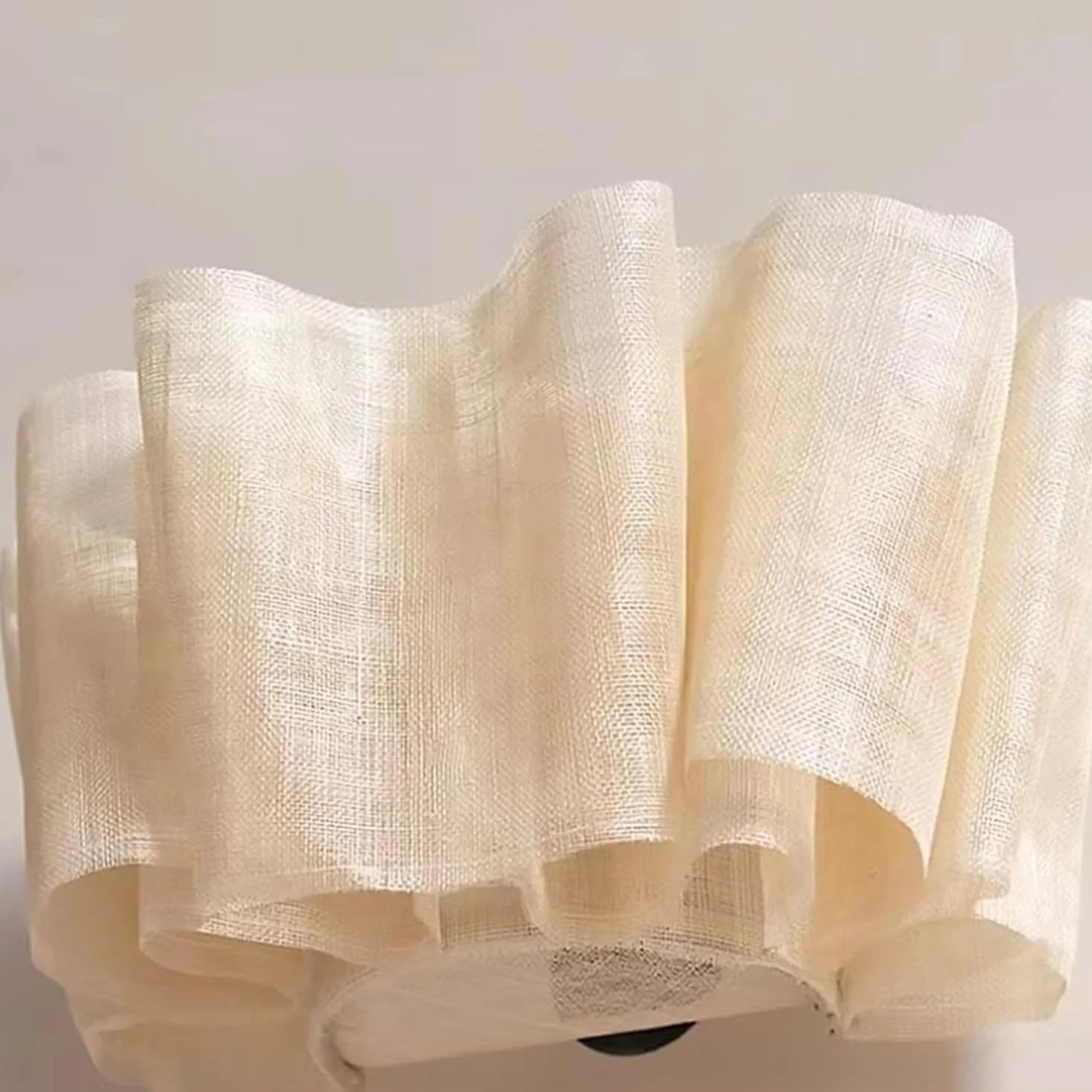 Beige textured fabric roll on a light gray background