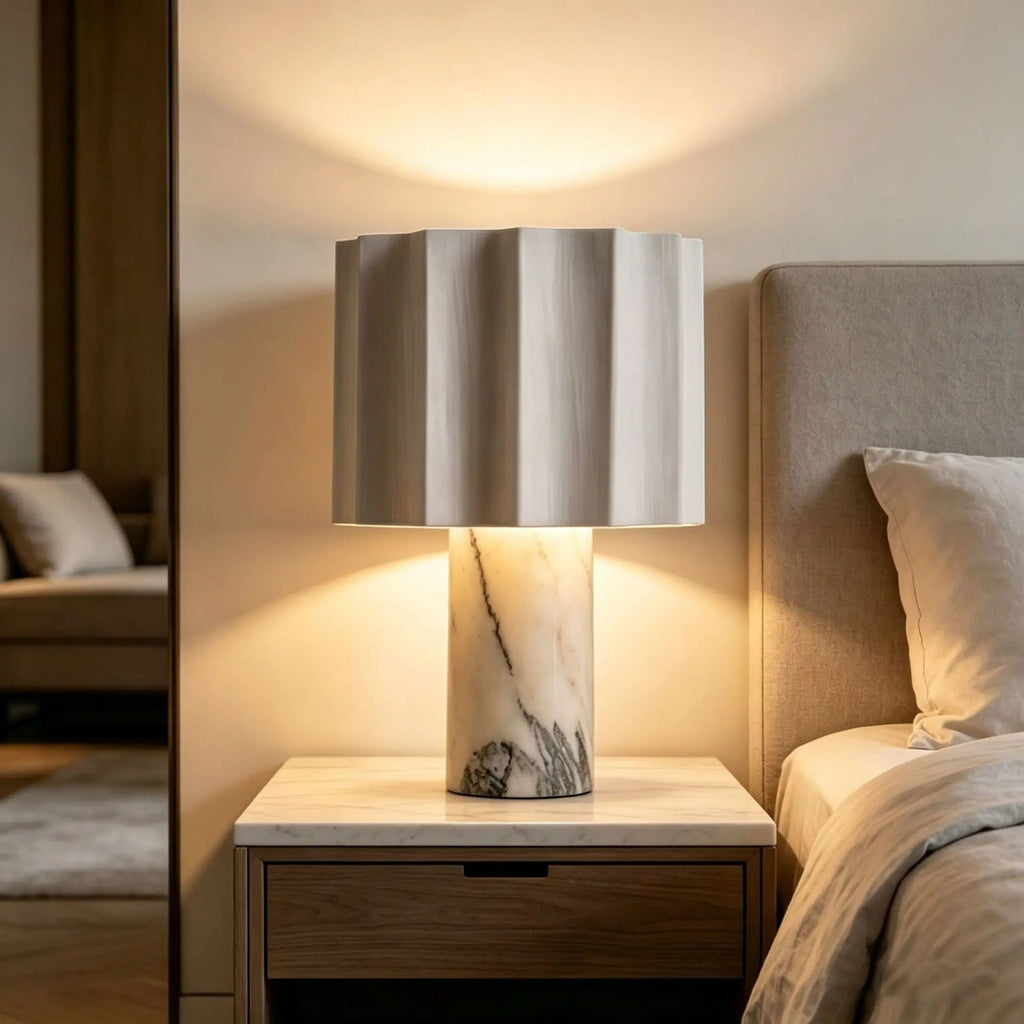 Modern lamp on a nightstand next to a bed in a bedroom setting