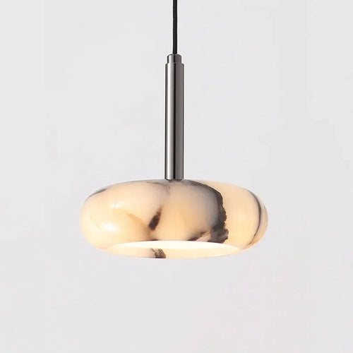 A modern pendant light with a rounded, disc-shaped translucent shade in a cream and black marbled pattern, suspended by a slim vertical metallic rod against a light gray background.