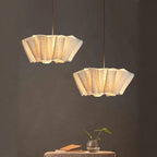 Two hanging pendant lights with a textured design on a dark background.