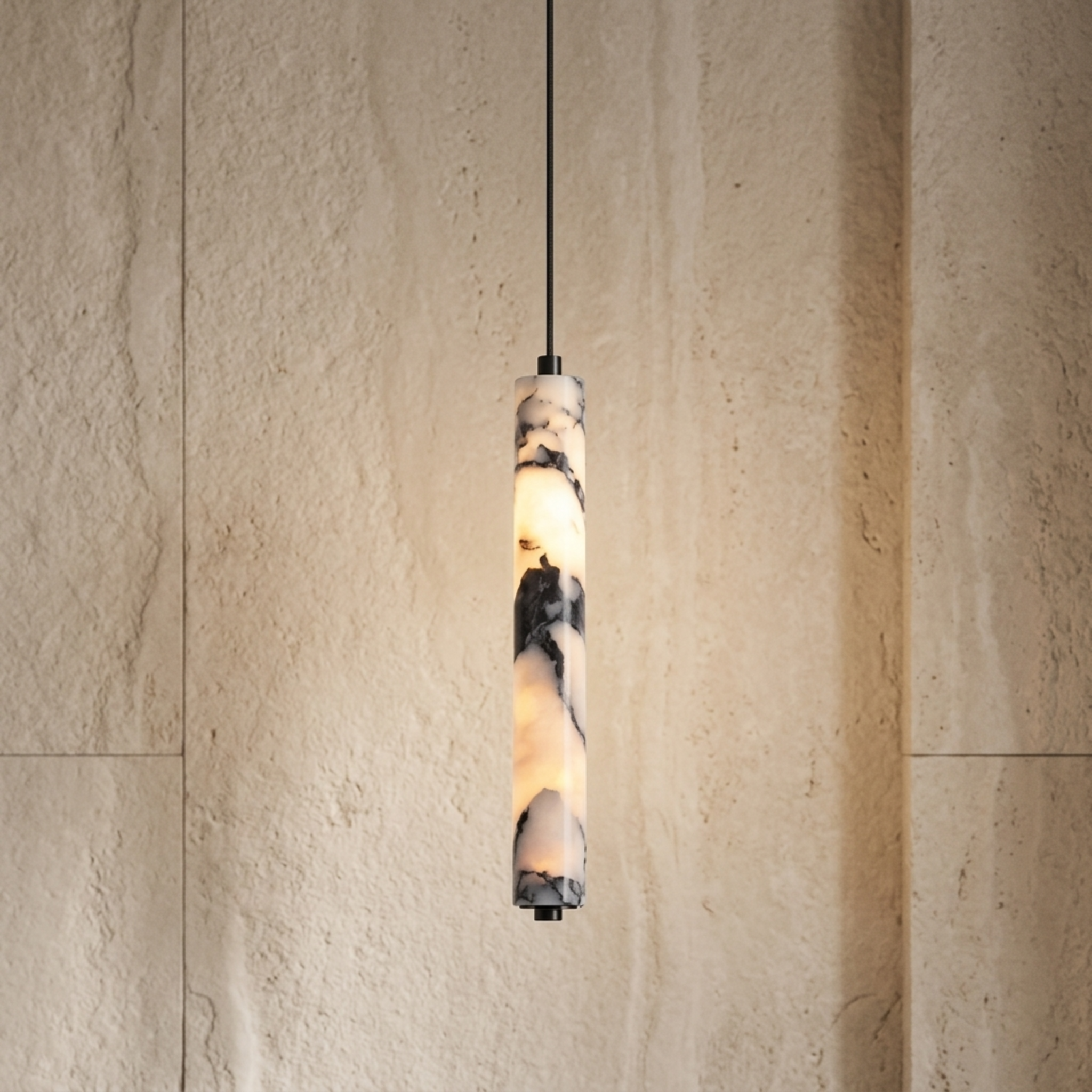 A modern cylindrical pendant light with a marbled stone or resin shade glowing warm white, suspended by a thin black cord against a textured beige stone wall.
