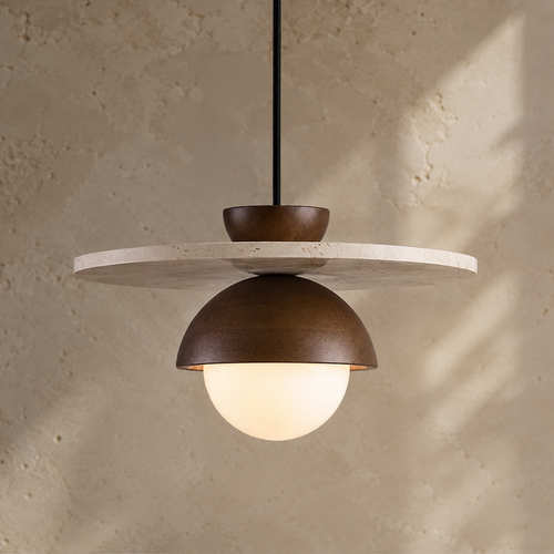 A modern pendant light with a dark bronze dome shade, a white frosted globe bulb, and a round light gray stone disc, suspended against a textured beige plaster wall.