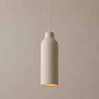 A minimalist pendant light with a textured beige ceramic bottle-shaped shade, suspended by a thin white cord against a matching beige background.