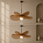 A hanging pendant light with a woven rattan or wicker wing-like shade in natural tan, suspended from a black rod with a white globe bulb. The image shows two stacked views of the same product in a beige interior, with dimension lines labeled 80CM and 50CM to indicate size variation.