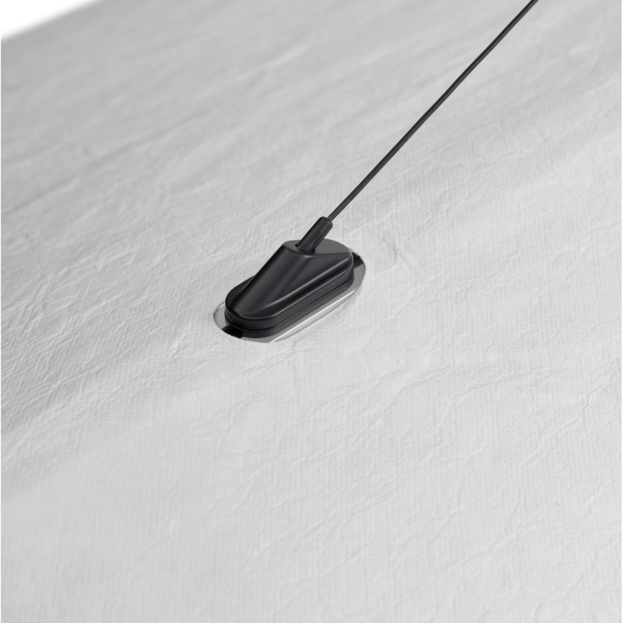 Black magnetic strip with a cable on a white background