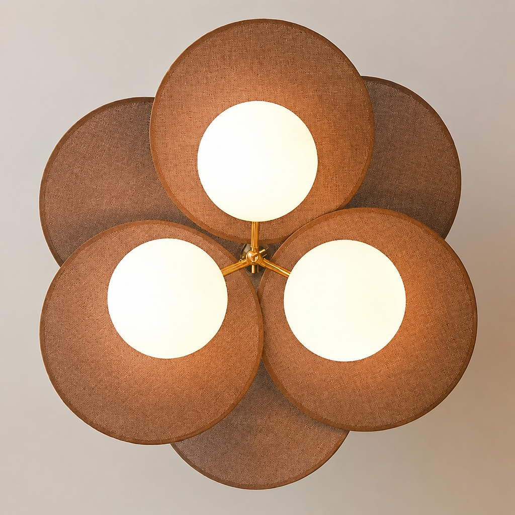 A modern five-light ceiling fixture with overlapping circular fabric shades in a warm brown tone and glowing white circular light centers, mounted on a neutral light gray wall.
